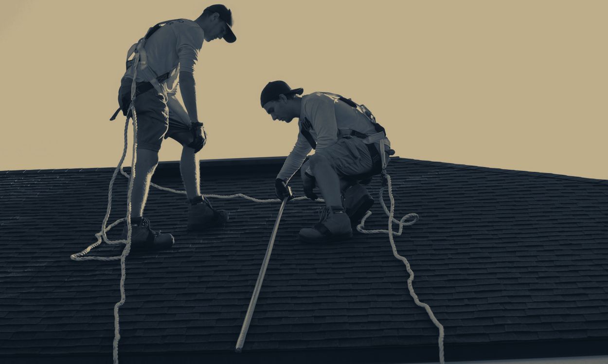 Two roofers measuring an asphalt shingle roof