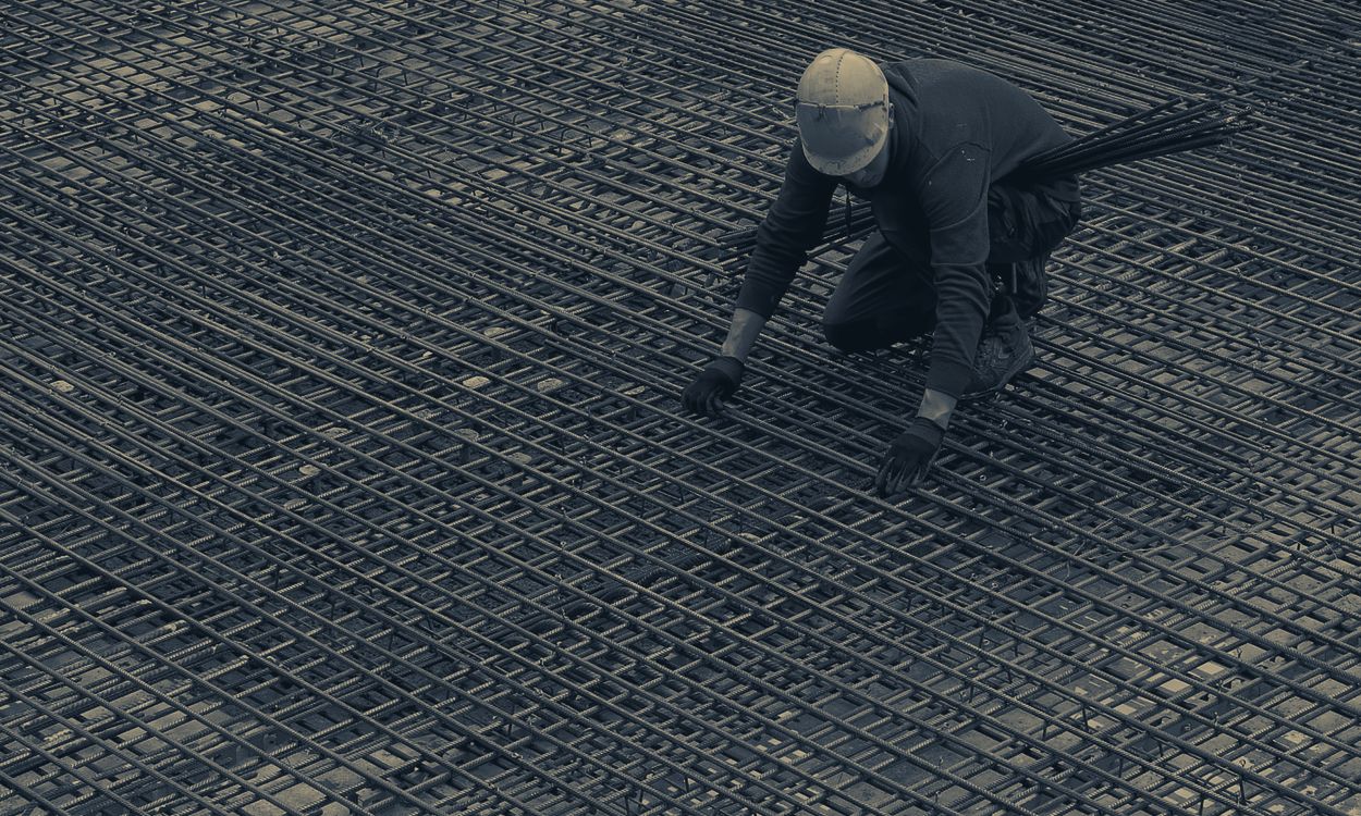 Worker tying rebar on a concrete deck